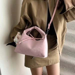 Pink half-moon crossbody bag with drawstring closure and cute dog plush pendant
