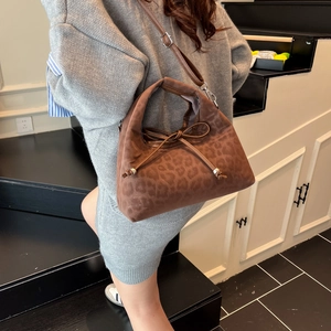 Brown leopard print suede handbag with drawstring bow detail on a stylish crossbody bag