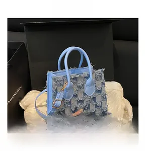 Détail du sac à damier en jean bleu clair avec bords effilochés et boucles en métal doré