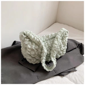 Detail of light green popcorn texture fabric on a cloud-shaped shoulder handbag