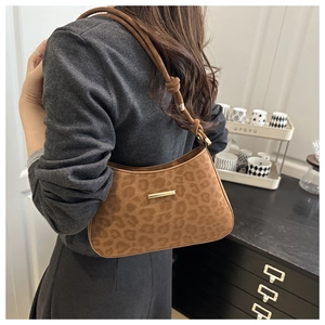 Detail of leopard print suede shoulder bag with knot strap and gold metal accents