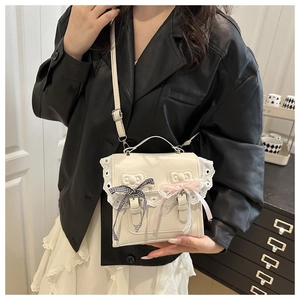 Detail showing lace trim, checkered bows and cat embossed patterns on cream PU bag