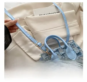 Détail de la bandoulière réglable en cuir et patchwork de denim du sac à main