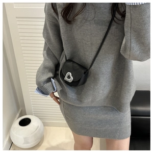 Gros plan d'un mini sac à bandoulière en cuir noir avec un fermoir cœur en métal argenté