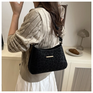Detail of black leopard print hobo bag with a gold metal bar and stylish shoulder strap