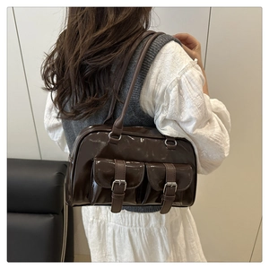 Détail du sac bowling en cuir verni marron foncé avec poches et finition brillante