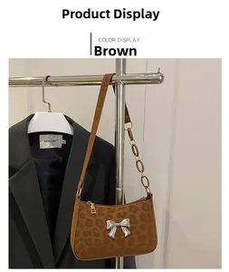 Close-up of brown leopard print suede underarm bag with silver bow accent and chain strap