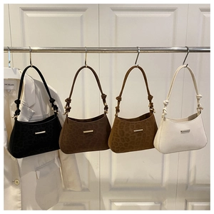 Detail view of leopard print and solid underarm bags with stylish hand-knotted shoulder straps