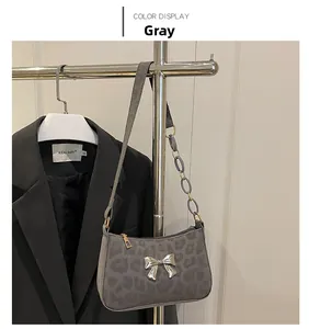 Detail of silver butterfly buckle on grey leopard print faux suede shoulder bag