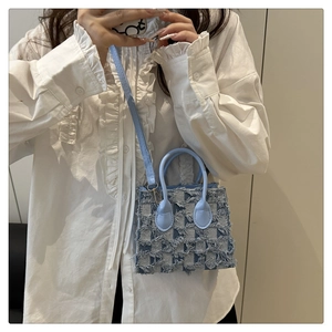 Détail du mini sac à carreaux bleu clair avec bords effilochés et fine bandoulière