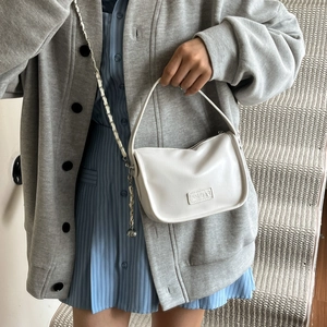 Borsa a mano bianca in pelle PU con tracolla a catena indossata da modella in interni moderni