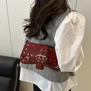 Dark red patent leather underarm bag with metallic rivets and punk buckle detail