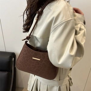Deep brown leopard print underarm bag with gold metal buckle and knotted strap detail