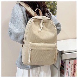 Detail of striped corduroy backpack texture with woven zipper pull on minimalist cream bag