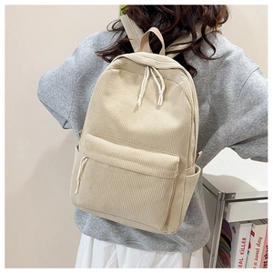 Detailed texture of beige corduroy backpack with woven rope zipper pull and front pocket