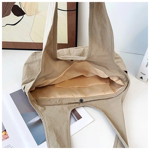Detailed interior of khaki tote bag showing metal snap button and inner storage pocket