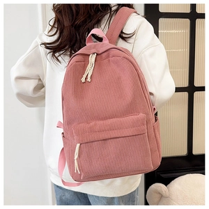 Detail of pink corduroy backpack texture showing main compartment and cotton rope zipper pull