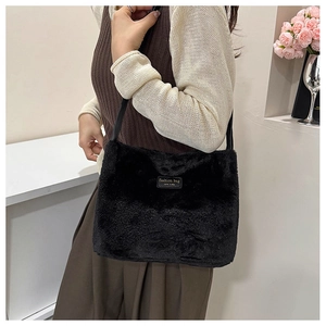 Détail du sac fourre-tout noir en fausse fourrure avec étiquette mode et bandoulière