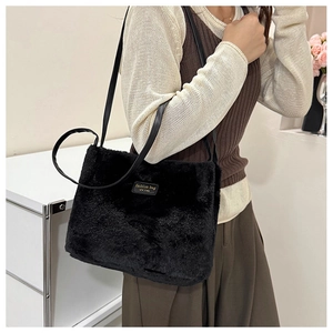 Détail du sac cabas en fausse fourrure noire avec étiquette et fine bandoulière