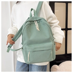 Detail view of mint green corduroy backpack showing striped texture and white rope zippers
