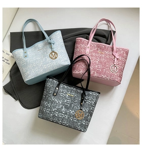 Trois sacs cabas en bleu, rose et gris avec texture mosaïque et pendentifs M en gros plan