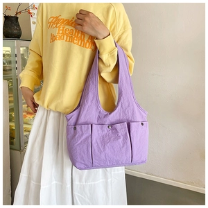 Detailed view of lavender nylon tote bag with three large front pockets and metal snaps