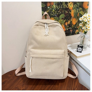 Detailed close-up of beige corduroy backpack with front pocket and cotton rope zipper