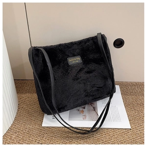 Détail du sac cabas en peluche noire avec étiquette mode et bandoulière pour l'automne