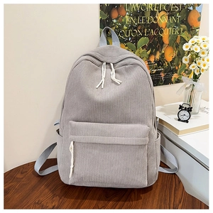 Light gray corduroy backpack detail with ribbed texture and front flap storage pocket