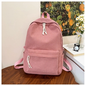 Detailed macro view of pink corduroy backpack fabric with zip pockets and woven handle