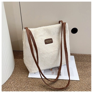 Détails du sac cabas en peluche blanc cassé avec anses en cuir marron et logo