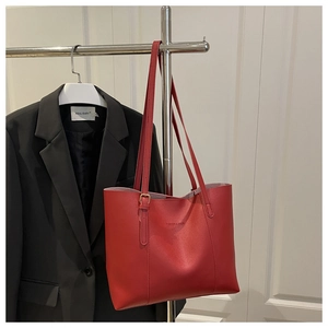 Detail of red faux leather tote bag with FASHION & BAGS embossing and adjustable strap