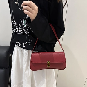 Sac sous le bras bordeaux de style français en cuir grainé avec fermoir doré sur modèle