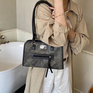 Fashionable sage green tote bag with contrast stitching and black leather trim