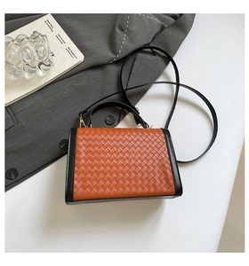 Detail of woven texture handbag with dual-tone orange-brown and black leather design