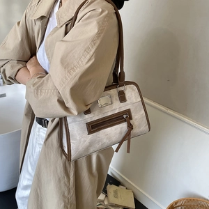 Retro cream shoulder tote bag with brown trim and tassel zipper shown on a model