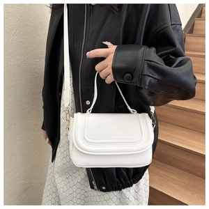 Detail of white PU leather saddle bag showing parallel U-shaped stitching and gold hardware