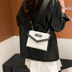 Women's woven texture crossbody bag in black and white contrast leather on a model