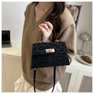 Detail of leopard print small square bag with gold twist lock and velvet texture finish