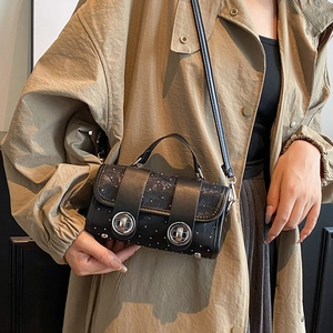 Elegante schwarze Umhängetasche mit weißen Punkten und Metallringen zum beigen Trenchcoat