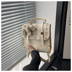 Close-up of beige polka dot backpack with cute bear print and textured leather finish