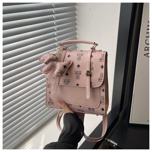 Pink polka dot backpack with bear print and cute bow charm detail in soft light