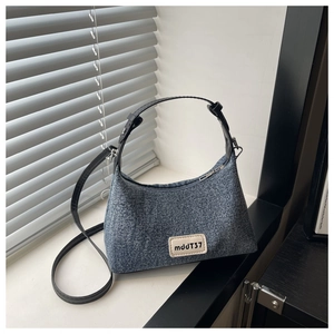 Detail of denim crossbody bag with black leather straps and mddJT37 square label