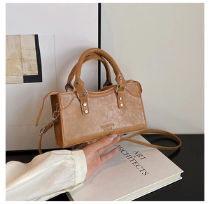 Close-up of vintage brown square handbag with textured PU leather and silver rivet hardware
