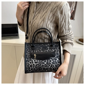 Detail of leopard print tote bag with gold zipper and adjustable black shoulder strap