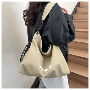 Detail of khaki nylon tote bag with Fashion print worn by model on a shoulder strap