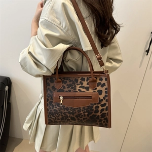 Grand sac cabas léopard avec anses marrons porté par un mannequin pour un look chic
