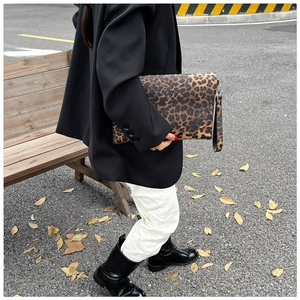Vue détaillée de la pochette enveloppe léopard avec dragonne amovible et texture fine
