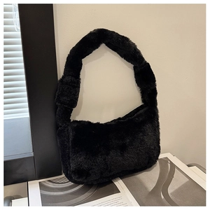 Detailed texture of black faux fur plush shoulder bag on a minimalist urban background