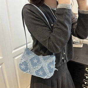 Sac sous le bras en jean bleu avec patchwork d'étoiles et bords effilochés